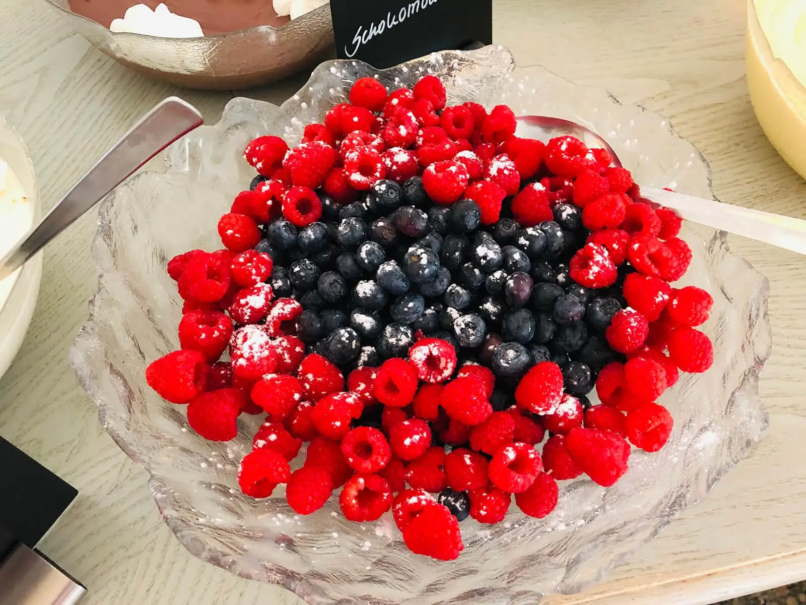 Himbeeren und Heidelbeeren unter Puderzucker, dazu Schokomousse