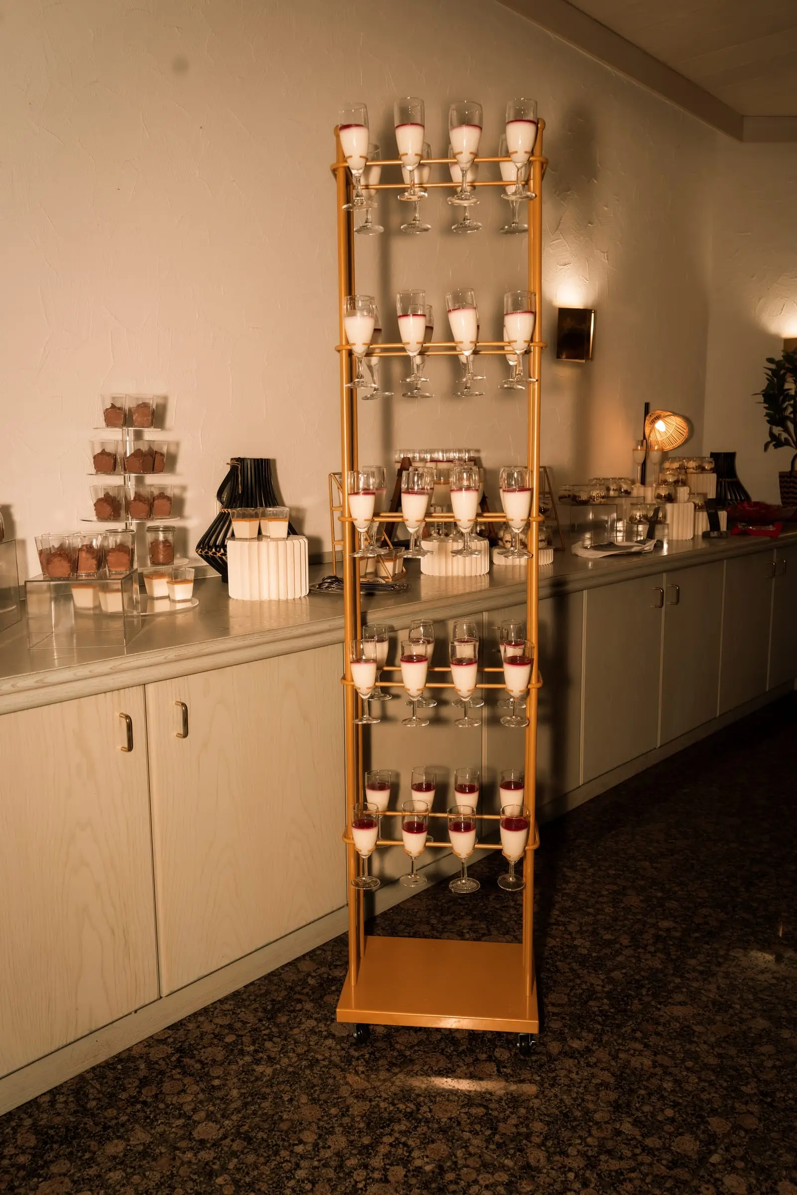 Panna cotta in Gläsern, aufgereiht auf goldener Etagere