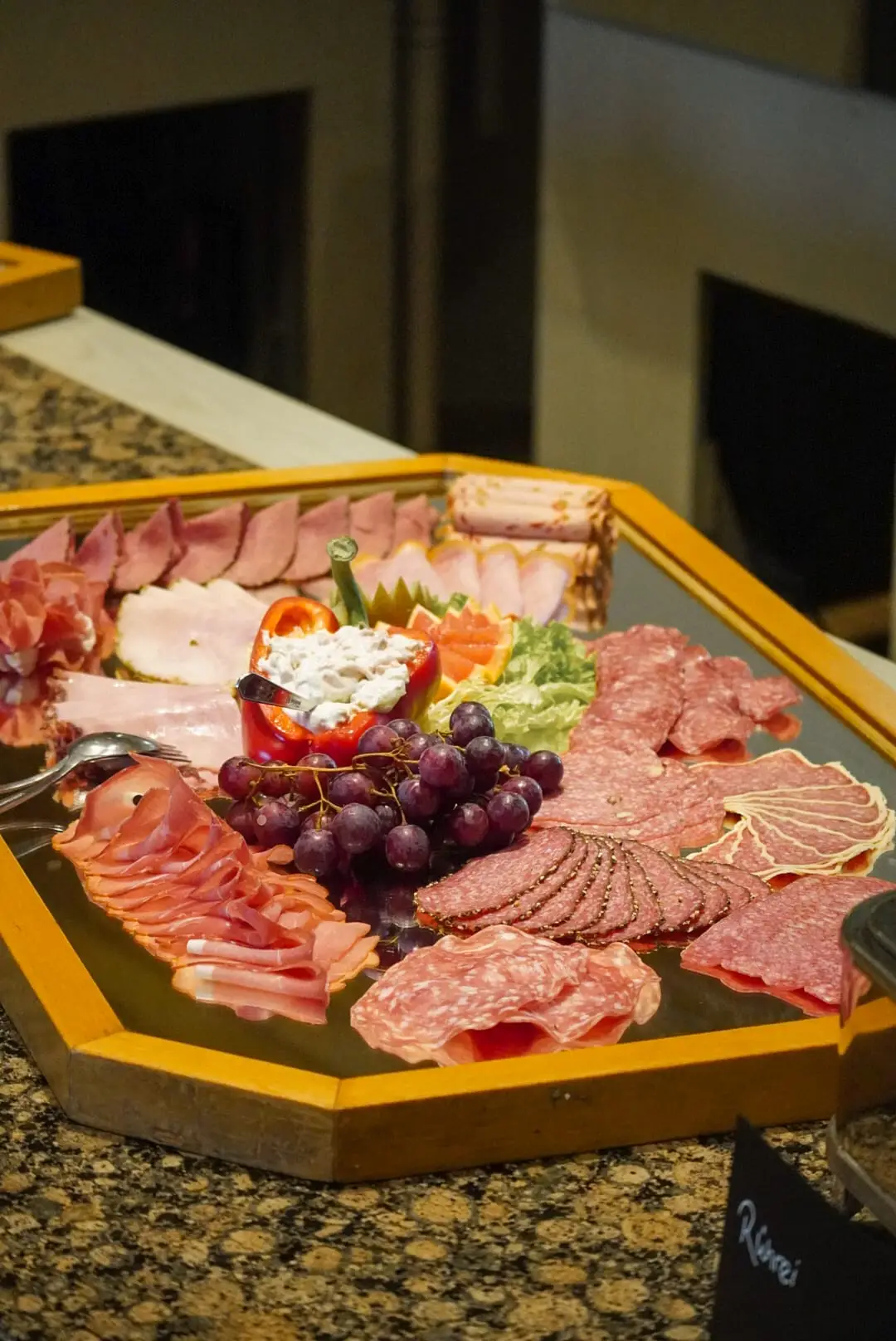 Schinken, Salami und Lachsschinken, dazu Weintrauben und gefüllte Paprika