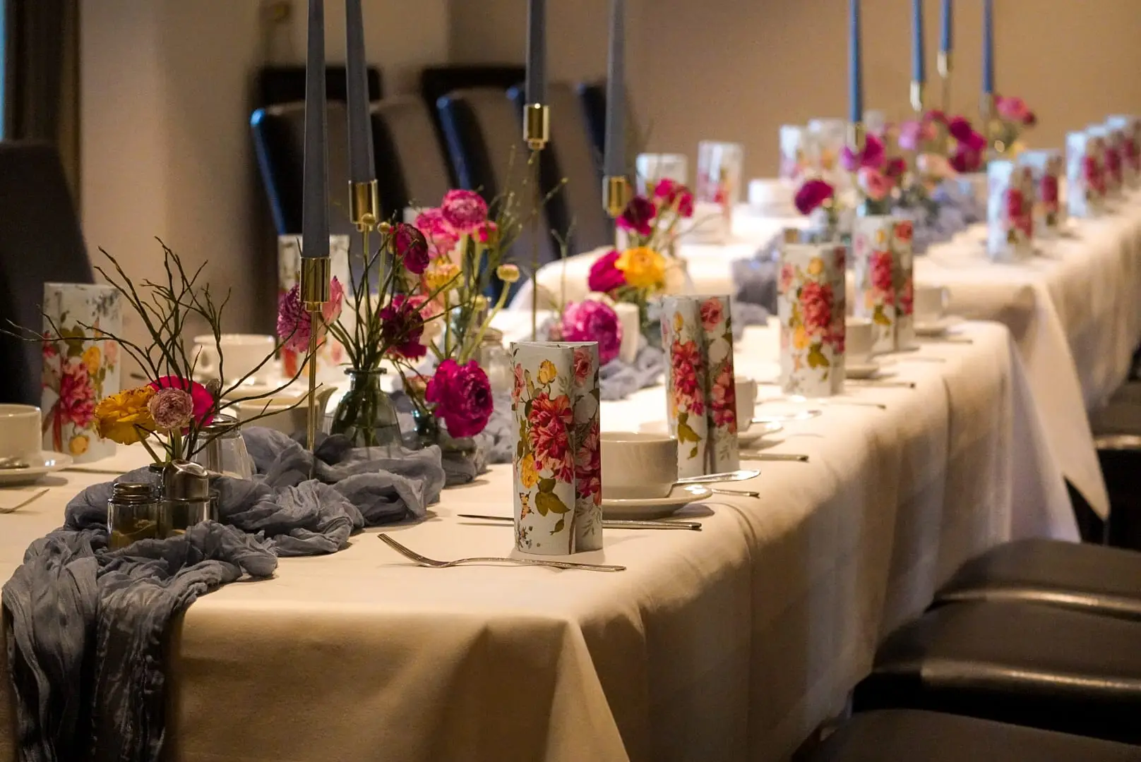 Die lange Tafel, eingedeckt mit Kerzen und Blumen — Frühstück als Fest
