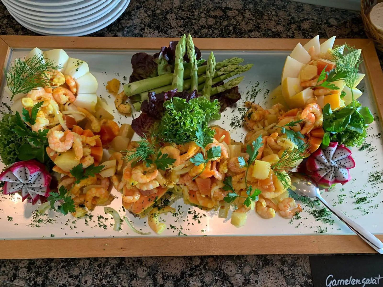 Garnelensalat in Melonenschiffchen, mit grünem Spargel und Dill