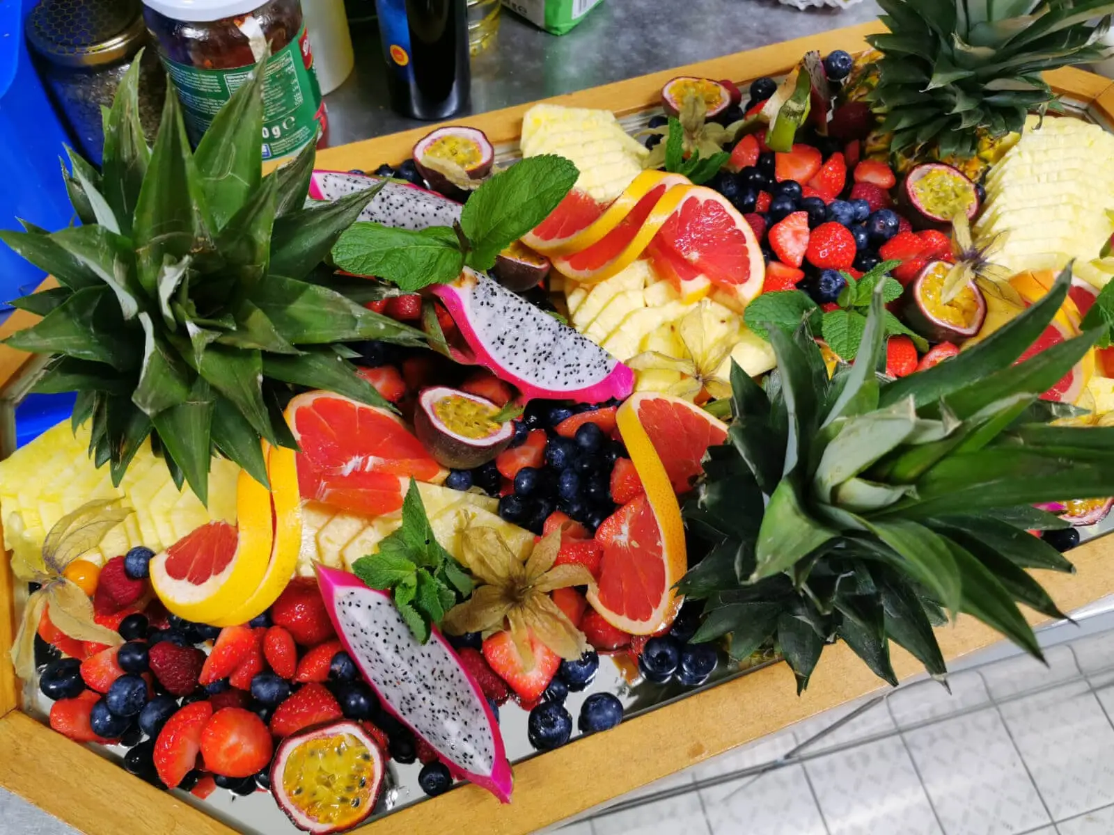 Obstplatte mit aufgeschnittener Ananas, Beeren und Maracuja