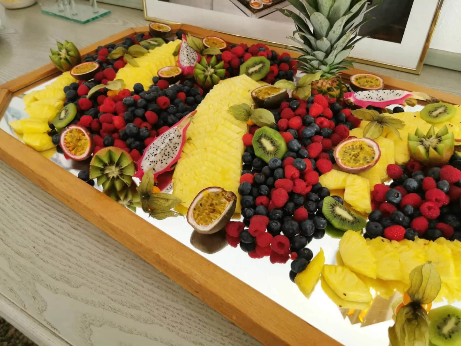 Aufgefächerte Ananas, Beeren und Kiwi mit Physalis