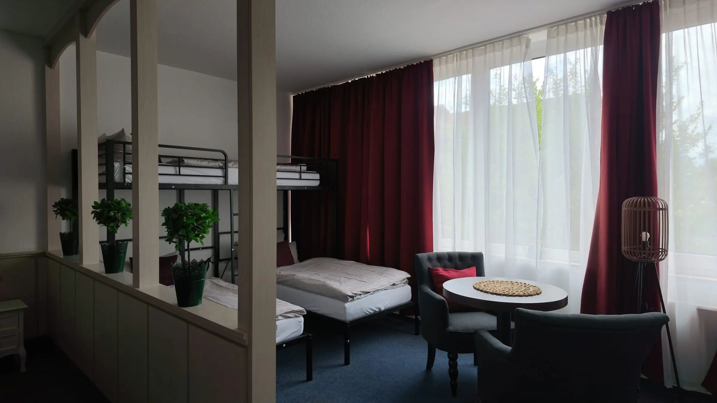 Sitzecke im Familienzimmer vor bordeauxroten Vorhängen